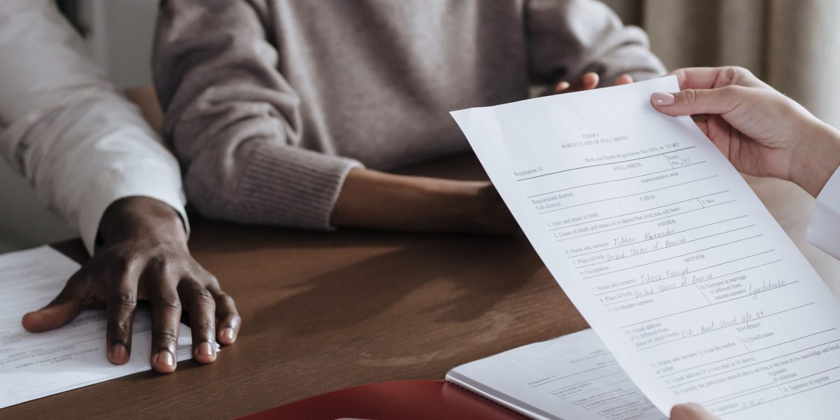 Two professionals discuss financial documents and investment strategies in an office setting.