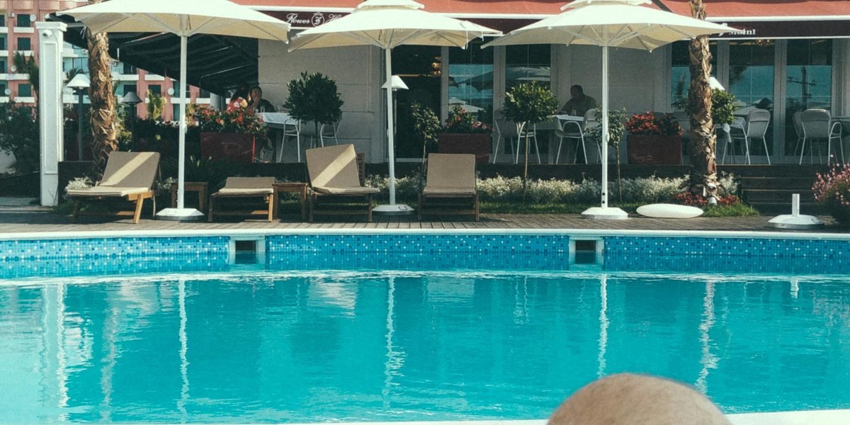 Guests enjoying the outdoor swimming pool and other amenities offered at a hotel.
