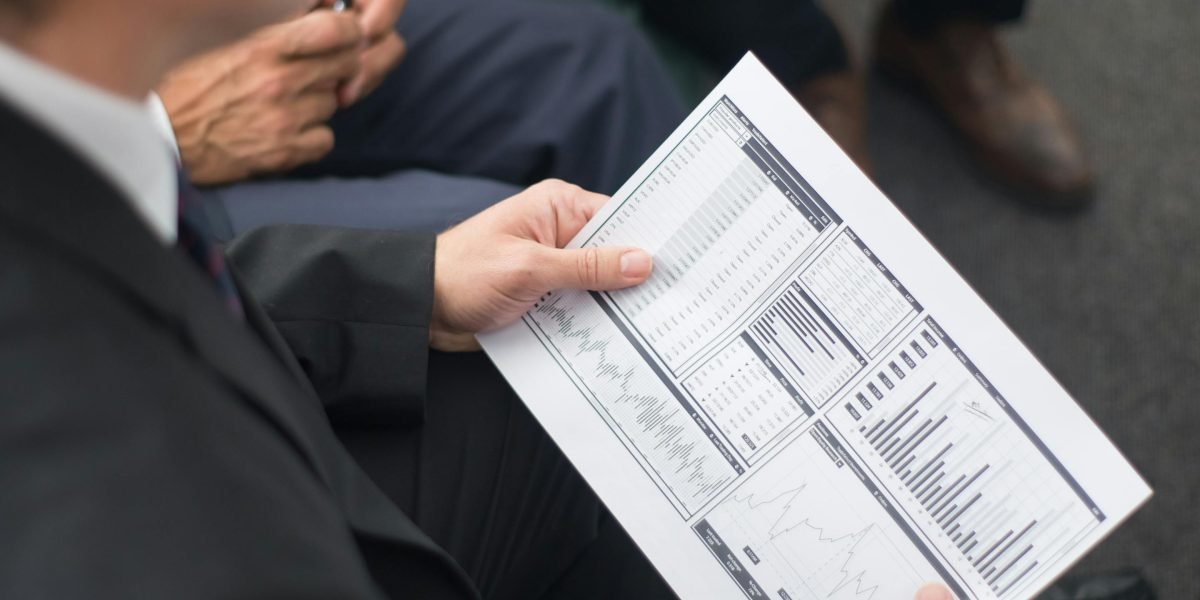 A professional reviewing financial documents, symbolizing the analysis of investment potential.