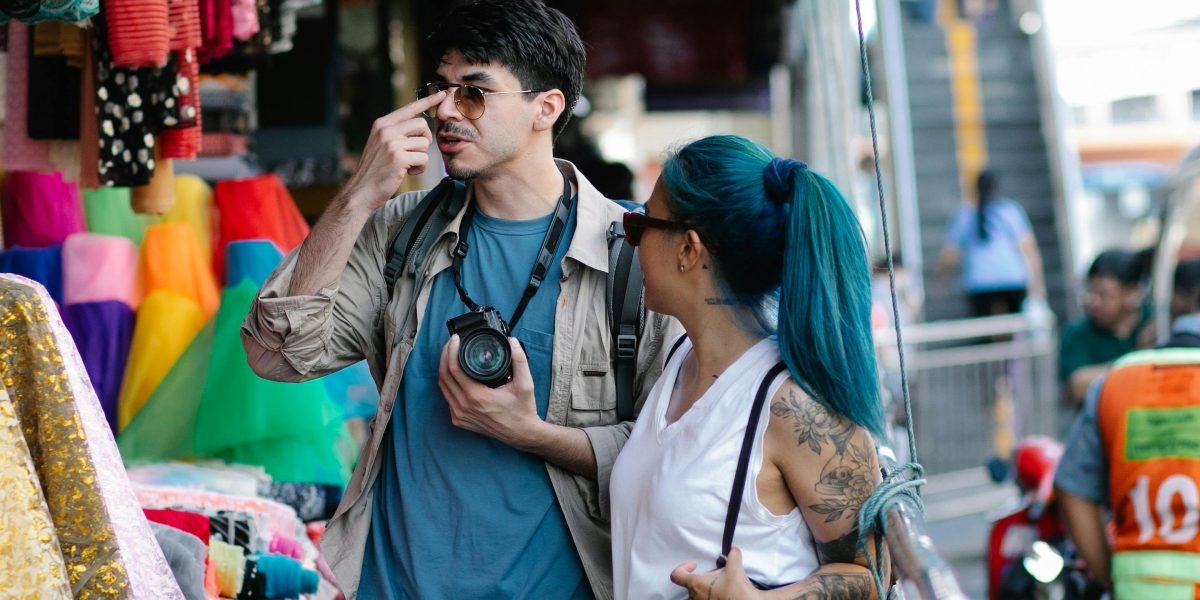 Tourists immersing themselves in the vibrant culture of a traditional marketplace, exploring local goods.