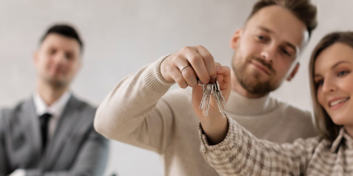 An expat tenant smiling confidently while receiving apartment keys, symbolizing a smooth move-in process facilitated by luxury hotel apartments.