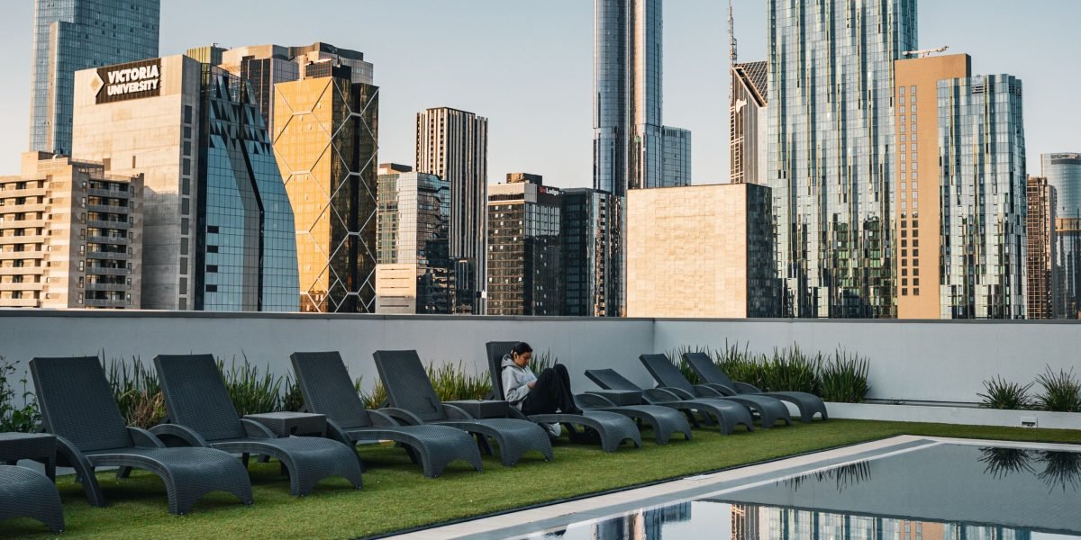 A modern traveler enjoying breathtaking skyline views from a luxurious rooftop infinity pool.