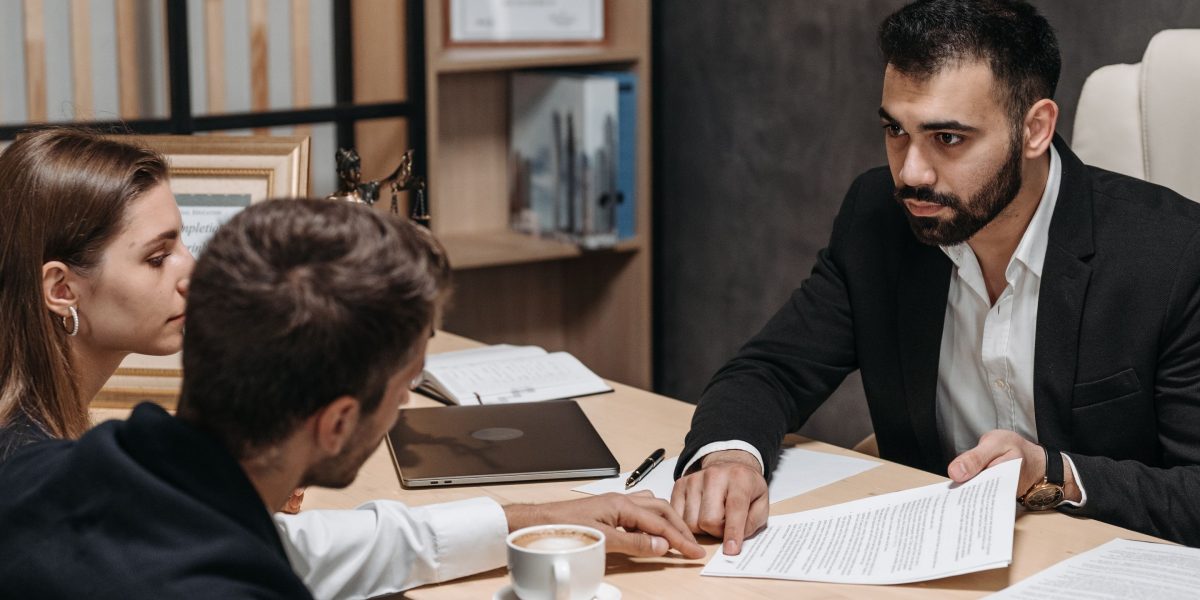 An individual discussing legal documents with an advisor, highlighting the importance of understanding regulations in property investment.