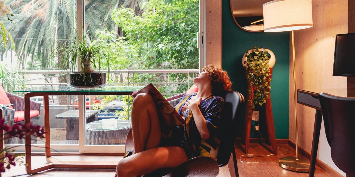 A person relaxing in a well-appointed hotel room, symbolizing the comfort and luxury of a hotel stay.